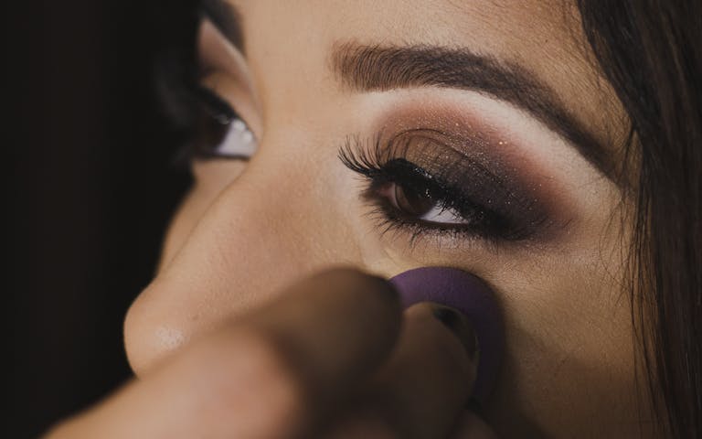 Close-up photo capturing the detailed application of eye makeup on a woman's face.